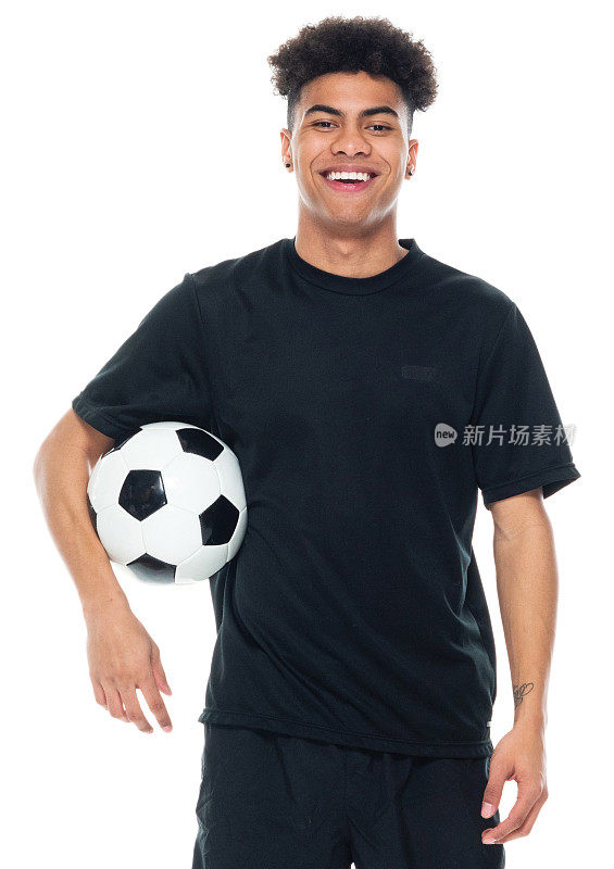 非裔美籍年轻男性运动员身穿跑步短裤站在白色背景前，手持足球进行足球运动和使用运动球