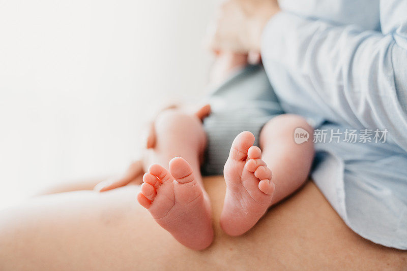 母亲正在给她的小儿子喂奶-注意宝宝的脚
