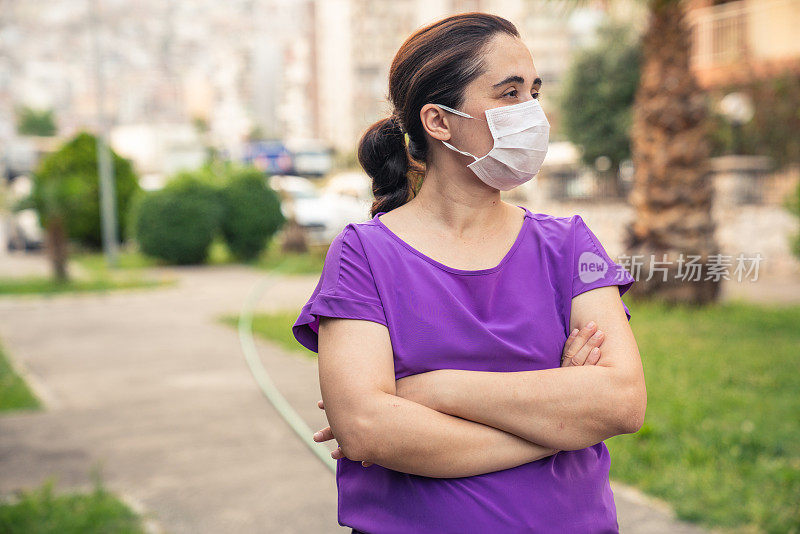 一位中年妇女戴着N95口罩走在街上