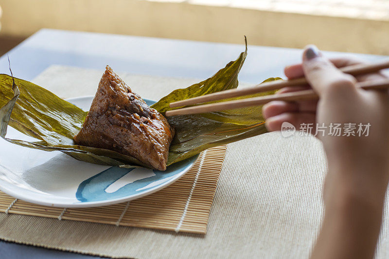 人们用筷子吃粽子