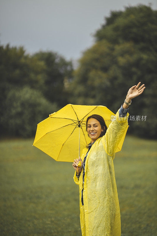 快乐的女人微笑着行走在雨天