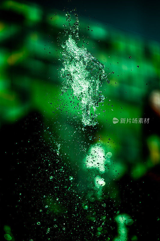 水花飞溅，绿色背景。水滴