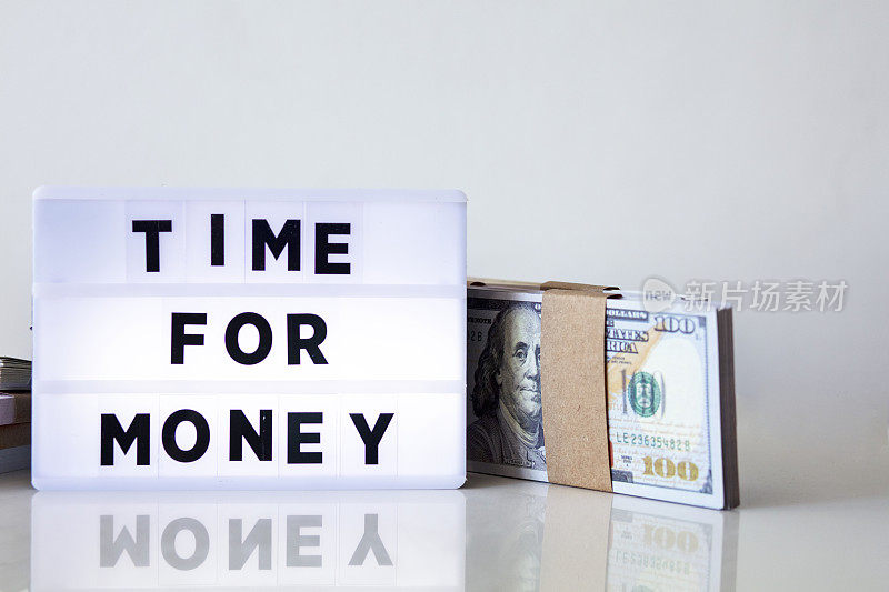 金钱时间概念与文字灯箱在家庭办公室。