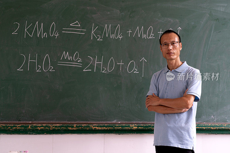 在黑板前的亚洲中年男教师的肖像