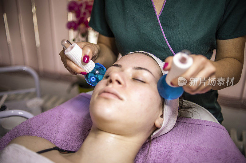美丽的女人在水疗沙龙的面部按摩-抗衰老疗法-年轻化和面部清洁