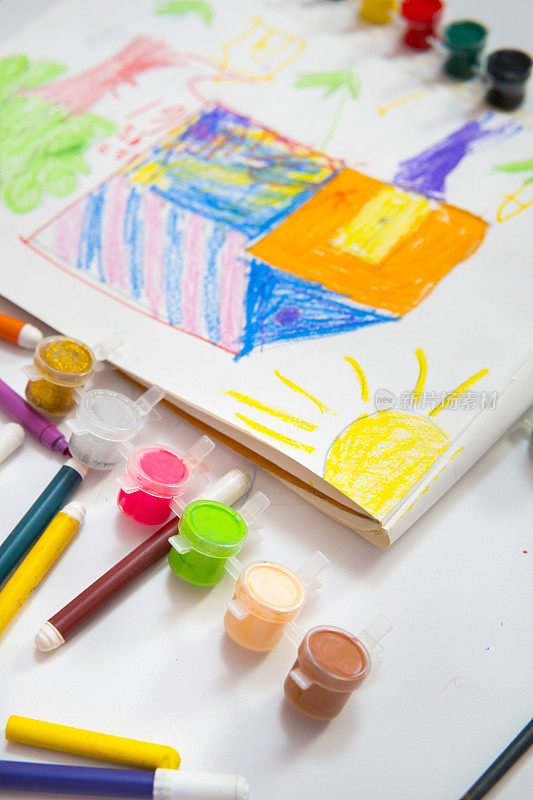 五颜六色的孩子们用不同的颜色画房子树和太阳。