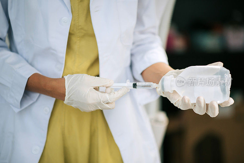 亚裔华裔女护士在临床准备生理盐水注射注射器