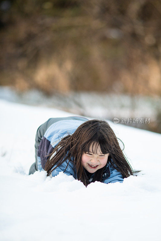 年轻女孩在雪中滑行，玩得很开心