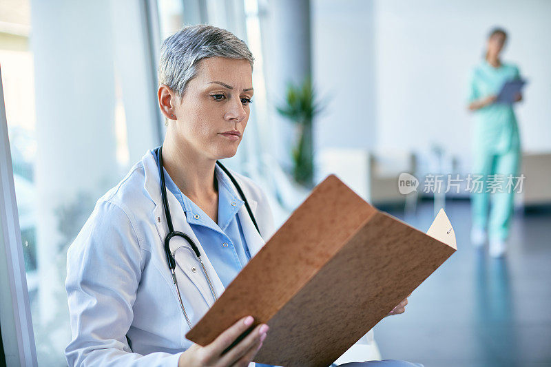 女医生分析医疗文件，同时在诊所工作。