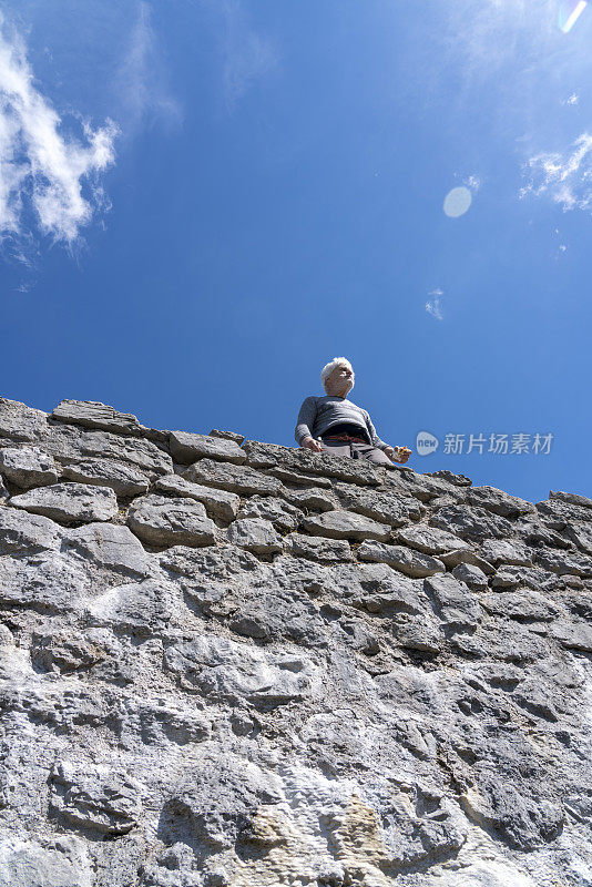长者们高高地站在古老的石墙上，背靠天空