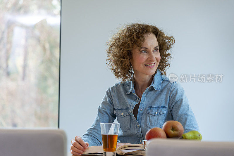 女人喝着热茶，看着外面