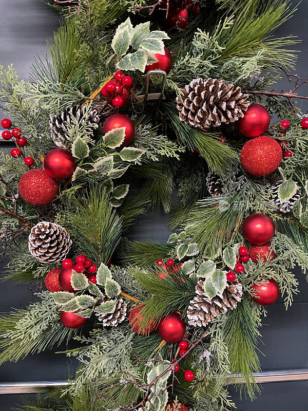 圣诞花环、人造红浆果、松针、洒上白雪的干松果、季节性装饰、高架视野的特写图像