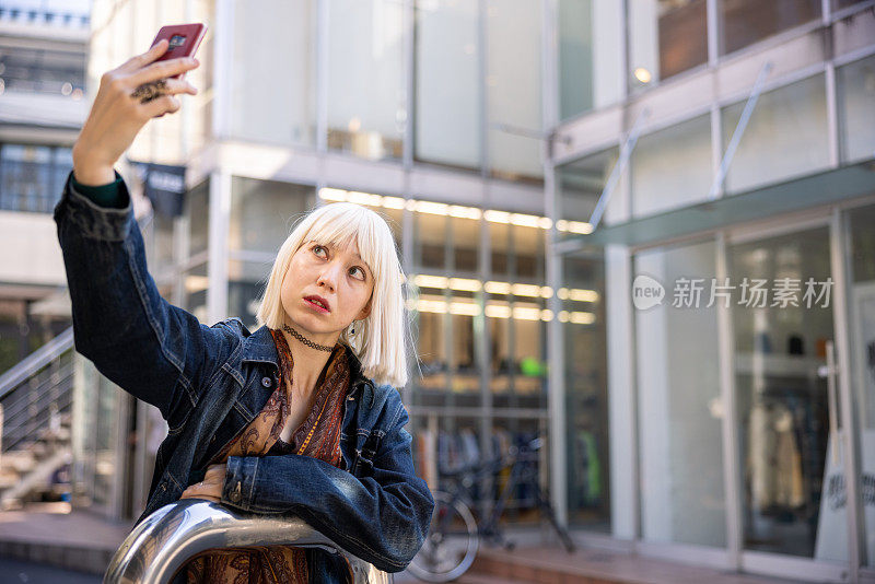 年轻女子戴着铂金假发在街上自拍