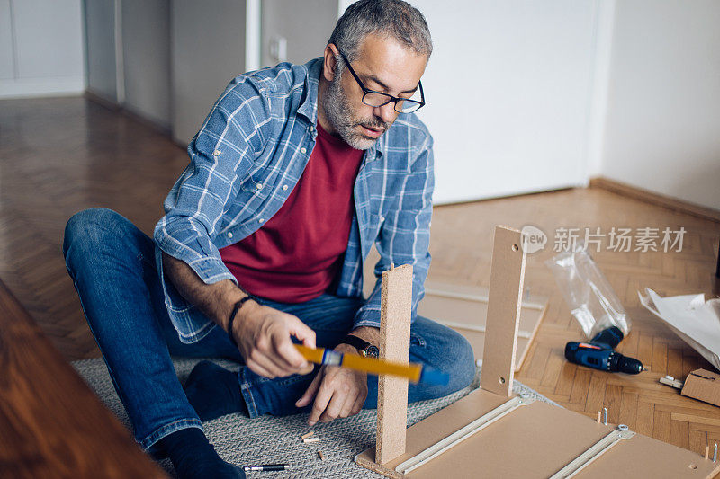 一个成熟的男人在家里做木制家具