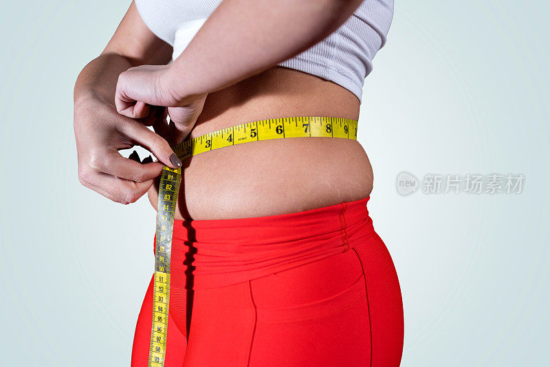 胖女人用卷尺测量肚子围