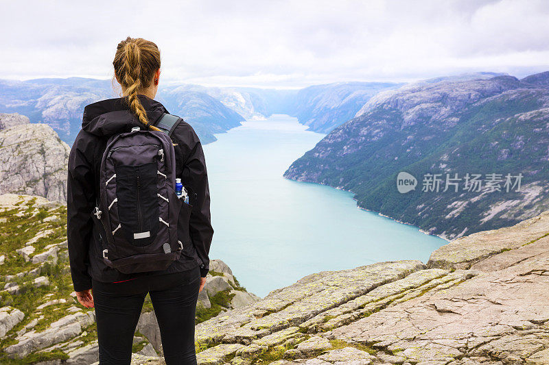在挪威吕瑟峡湾布道石悬崖徒步旅行的妇女