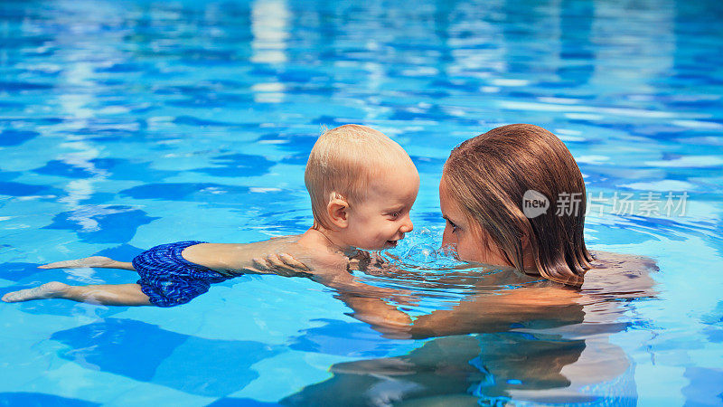 孩子和妈妈在游泳池里游泳