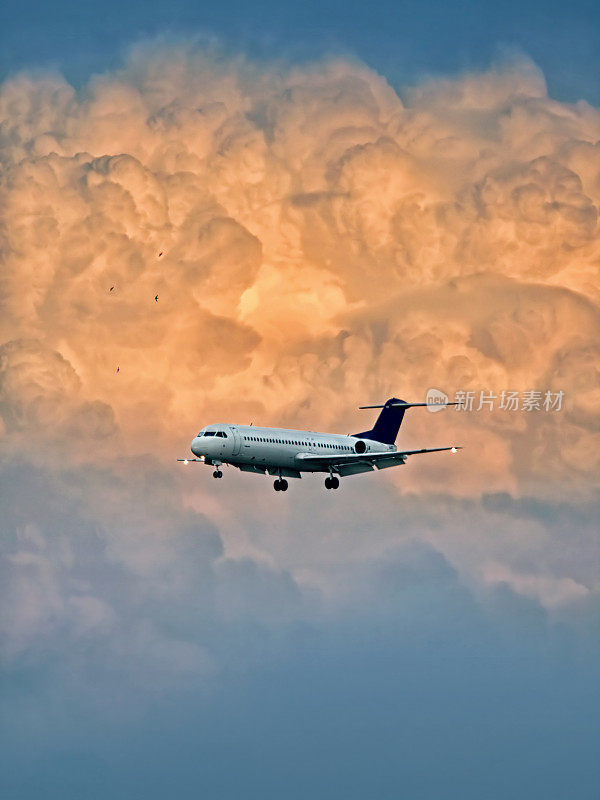 飞机在日落时带着乌云降落