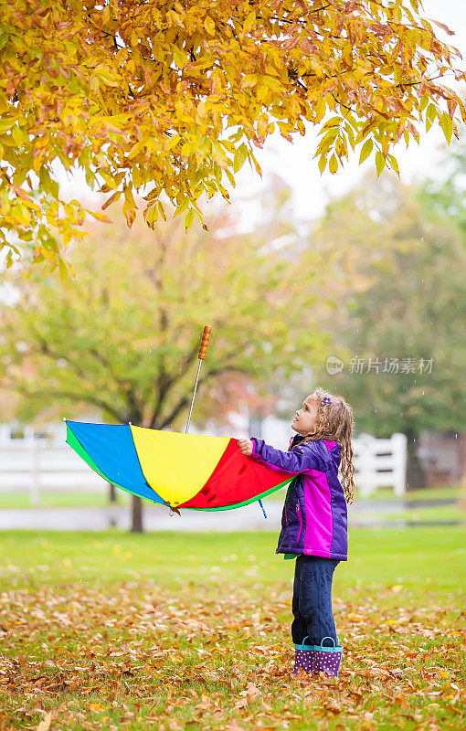 用伞接树叶的女孩