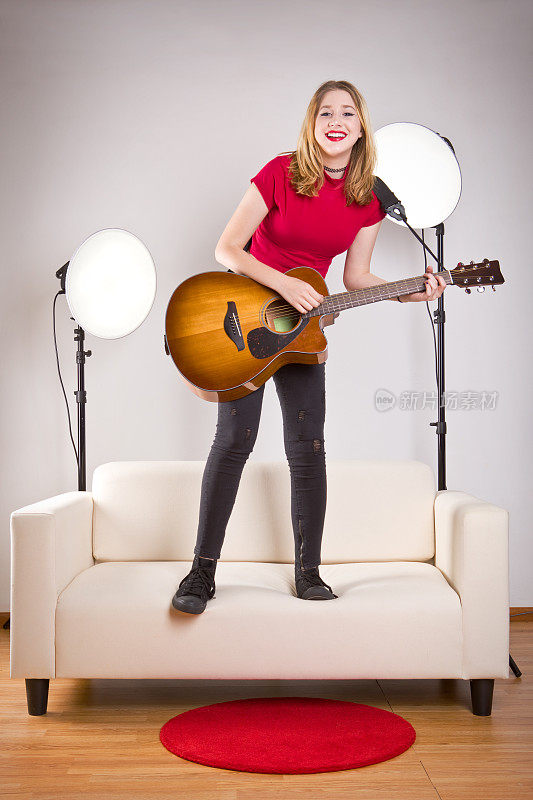 少女跳在沙发上弹吉他