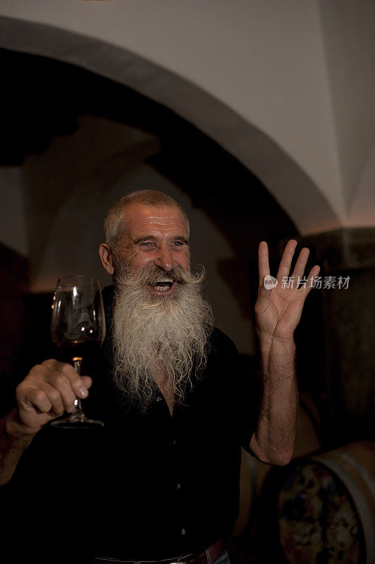 胡子老人在酒窖里举着酒杯
