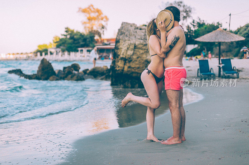 一对年轻情侣在海滩上接吻