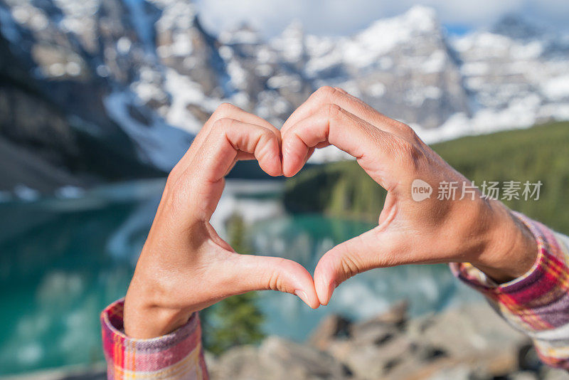 近距离的手使心形框架上的山湖景观