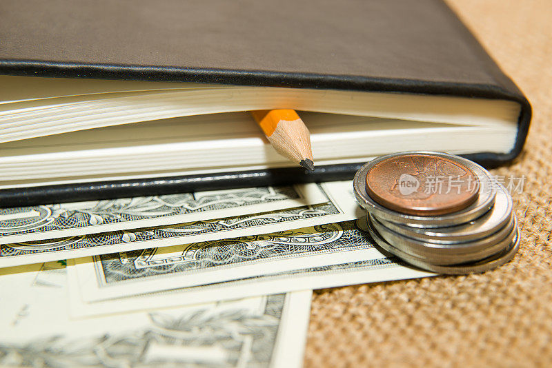 笔记本，铅笔和钱在旧纸巾上