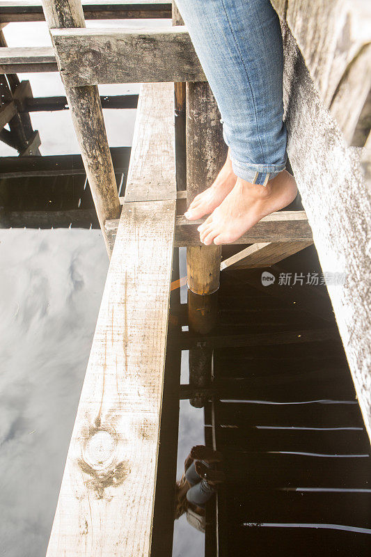 新西兰，一个女人的脚悬在湖边码头上