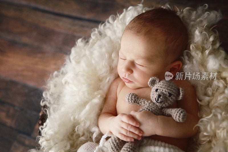 新生婴儿和泰迪熊睡觉