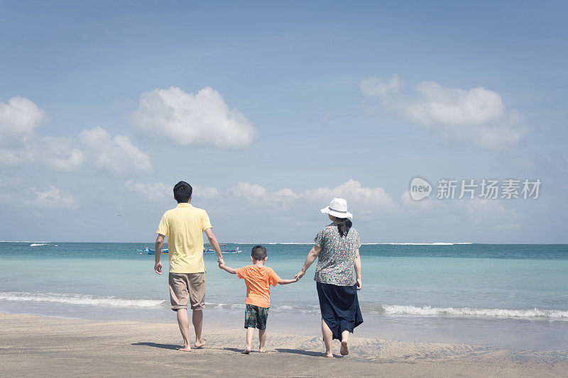 一家人带着一个孩子在海滩上玩