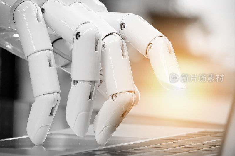 机器人，人工智能，机器人顾问，聊天机器人概念。机器人手指指向笔记本电脑按钮，带有闪光效果。