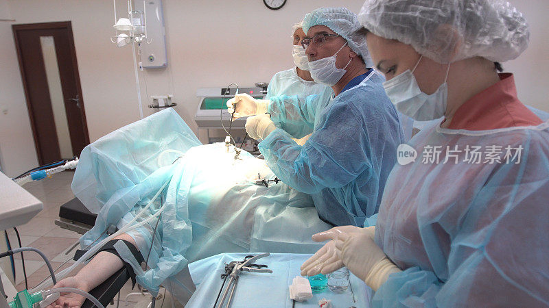 外科医生团队在手术室监测病人。使用腹腔镜设备进行手术。医院