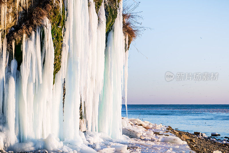 岩石和海洋上的冰柱。美丽的冬天的风景