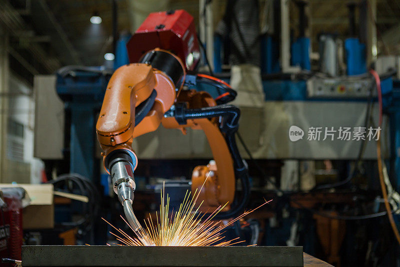 橙色工业机器人正在工厂焊接装配零件