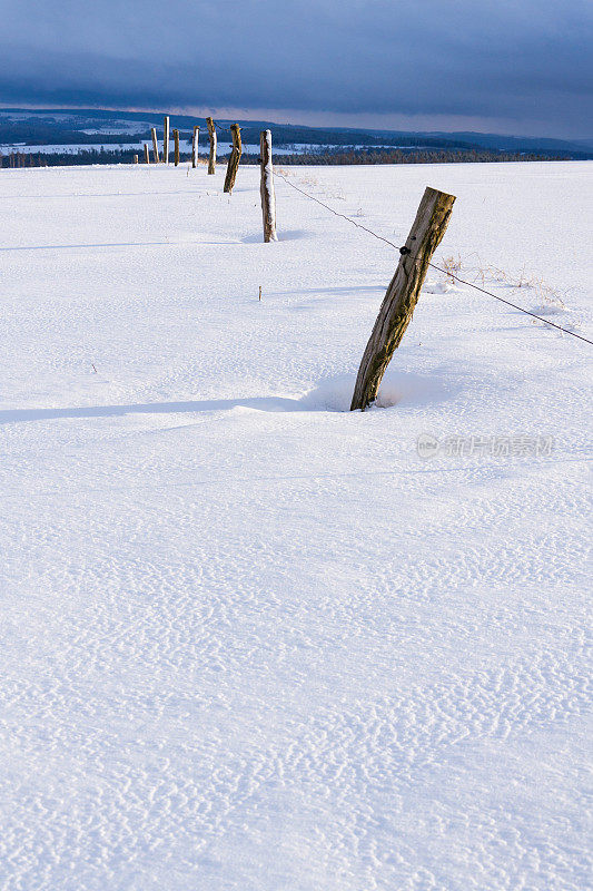 栅栏杆在多雪的冬季乡村晴天，天气预报概念