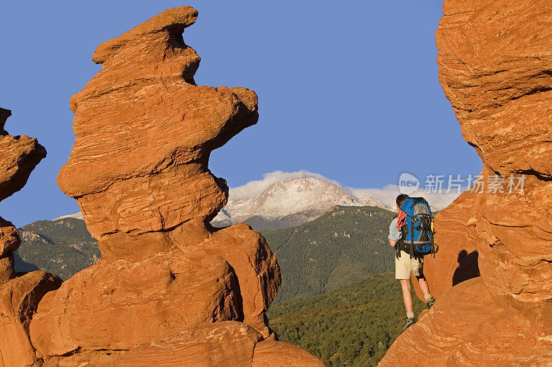 在岩石上看山的女人徒步旅行者