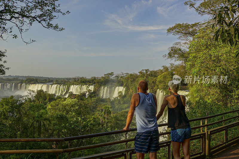 一对夫妇在南美伊瓜苏国家公园欣赏美丽的伊瓜苏瀑布