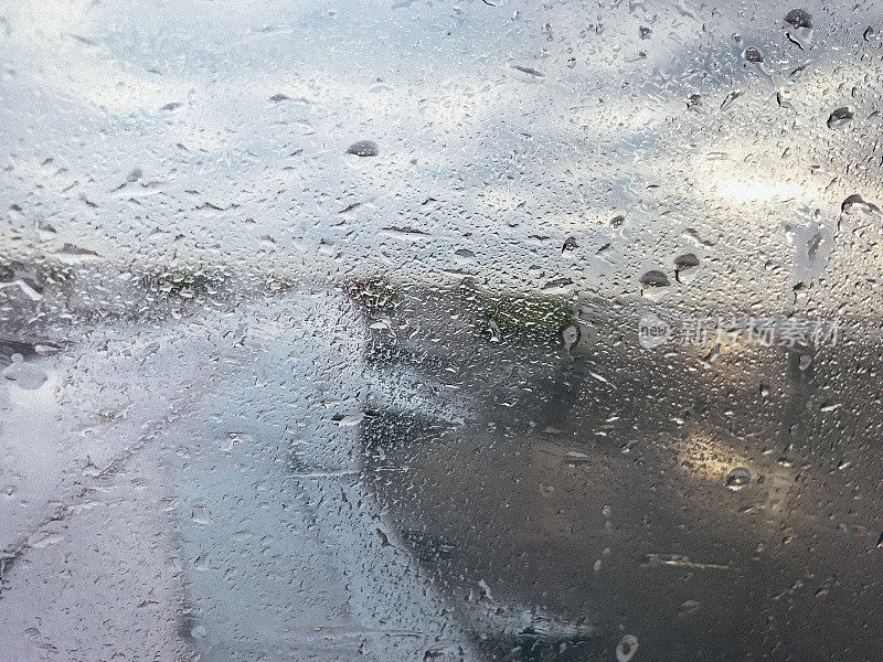 在一个下雨天，透过飞机窗户看到的机场跑道。