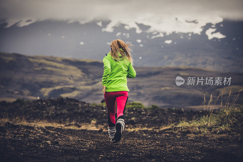 冰岛女运动员慢跑的后视图。