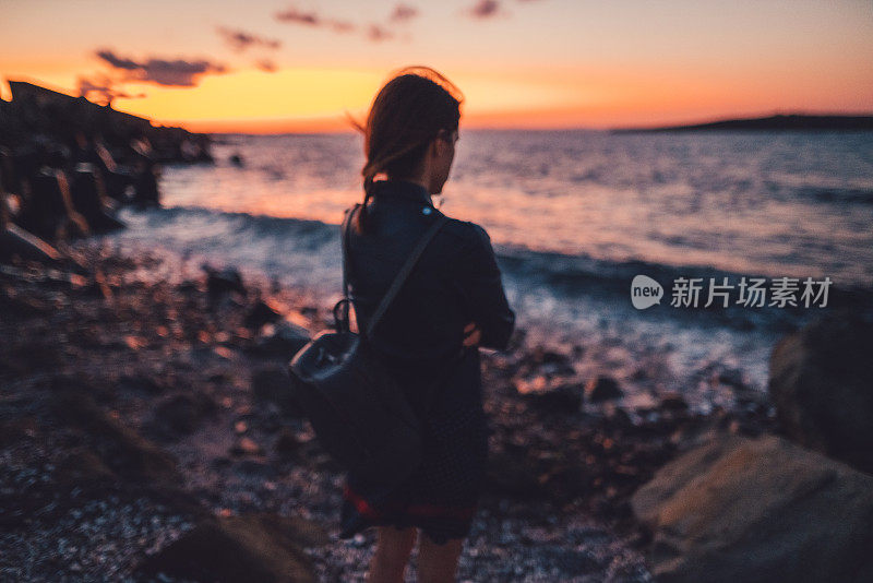 沮丧的女人在海边凝视夕阳