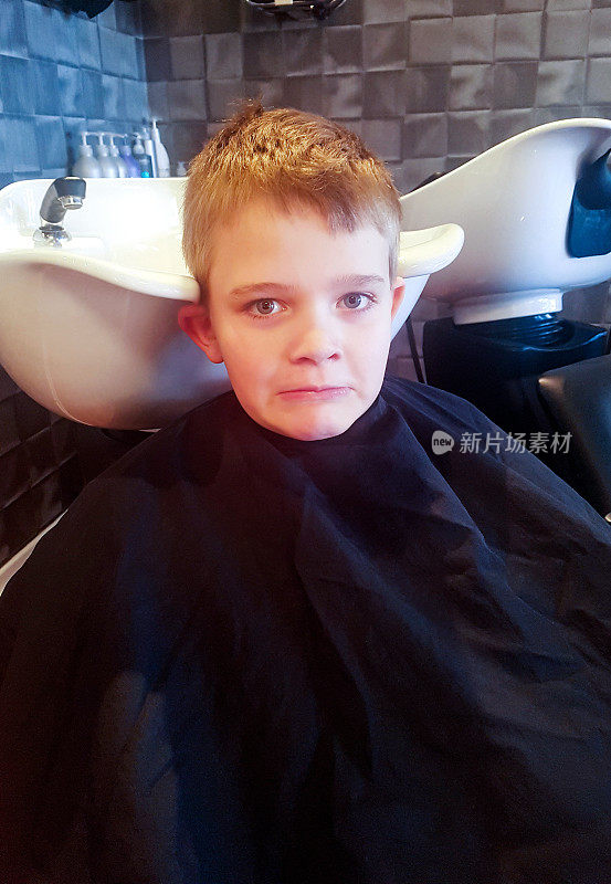 男孩在美发店等待理发时自拍