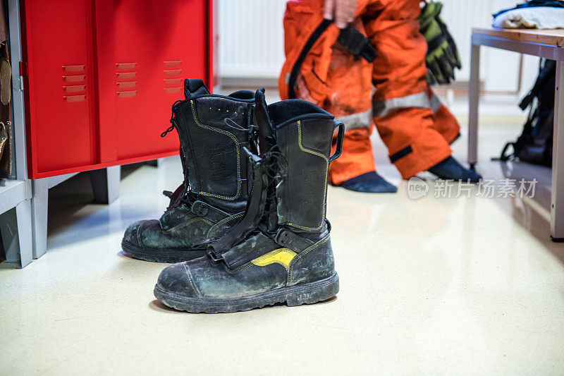 消防队员在消防站内取下他的鞋子特写