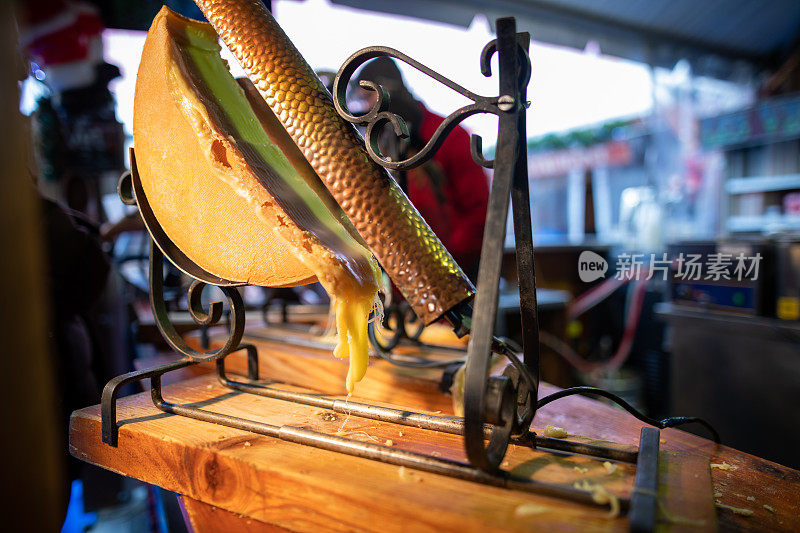 Raclette(传统的融化奶酪盘)在巴黎圣诞市场出售