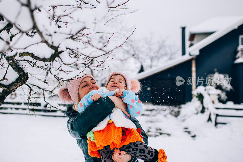 快乐的妈妈喜欢和她的孩子在雪地里玩