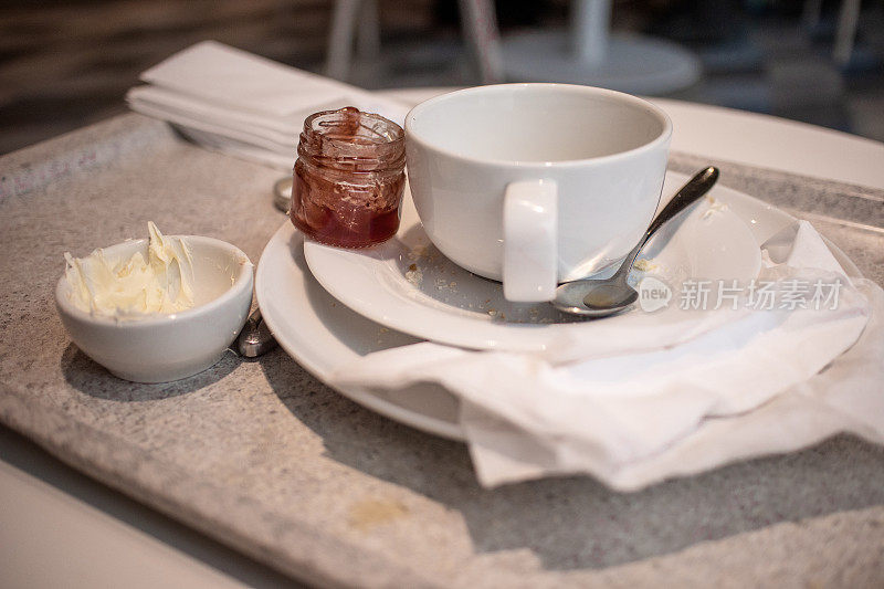 用空茶杯、空果酱壶、空奶油盘喝奶茶