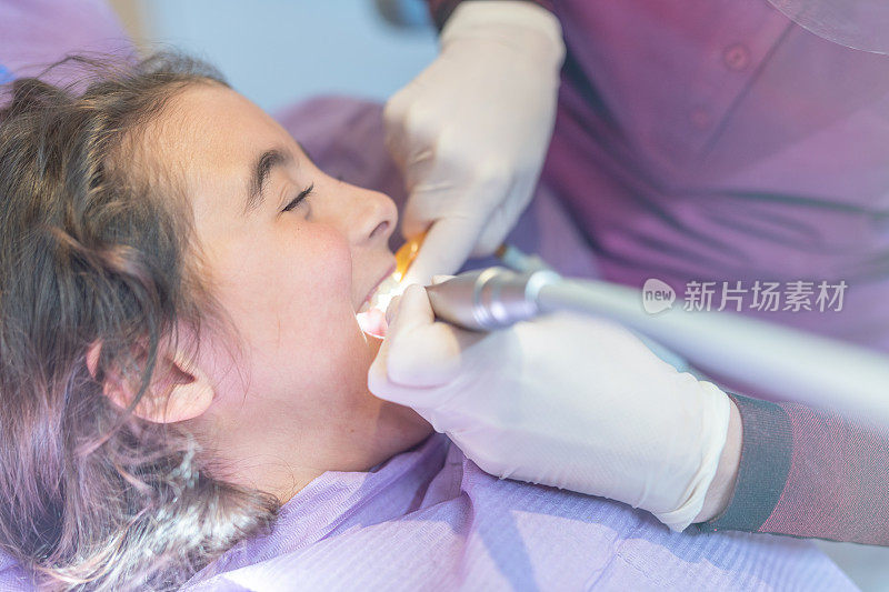 口腔卫生教育。微笑的小女孩在牙科诊所治疗