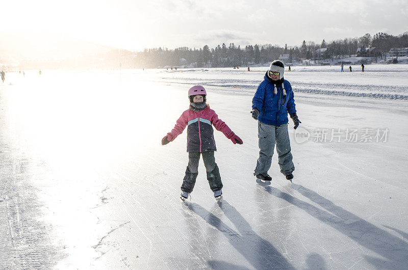 冬天，母亲和女儿在湖上的溜冰场溜冰