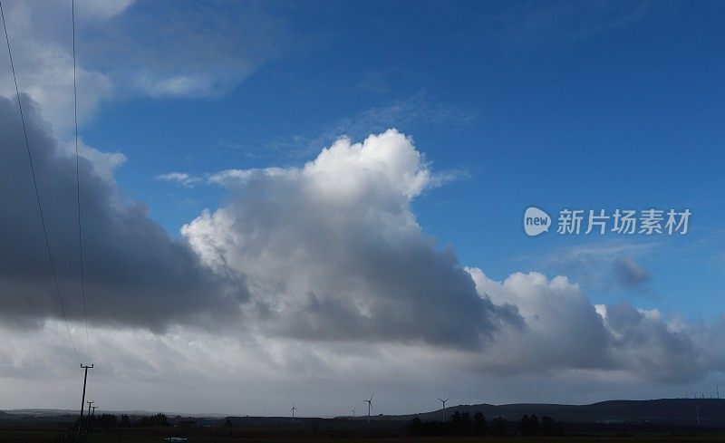 电线杆和风力涡轮机下的蓝天与大白云和复制空间