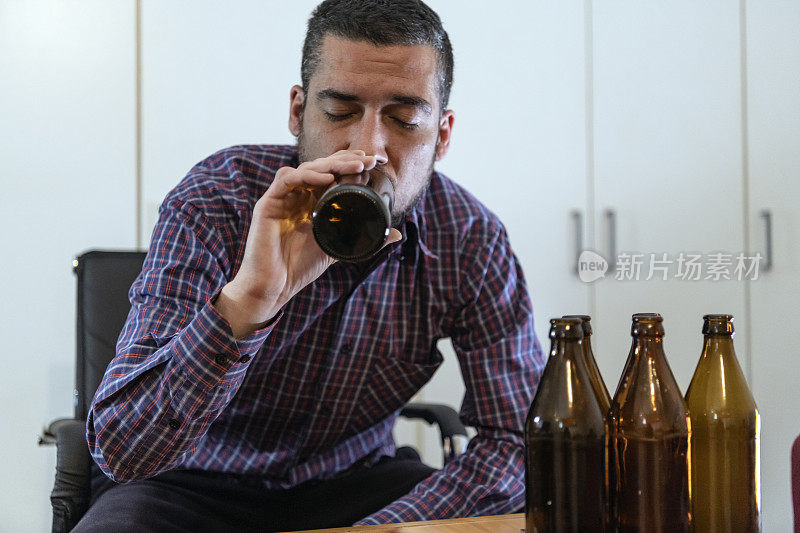 年轻悲伤的醉酒男子喝啤酒和酒精感到浪费，孤独和绝望的痛苦和情绪压力。人与酗酒、上瘾和男人抑郁的概念。